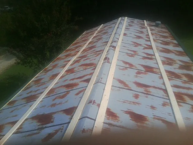 Rusted metal roof panels with new wood purlins before replacement — Storm Damage Roof Repair in Glenmont by Roofing Brothers