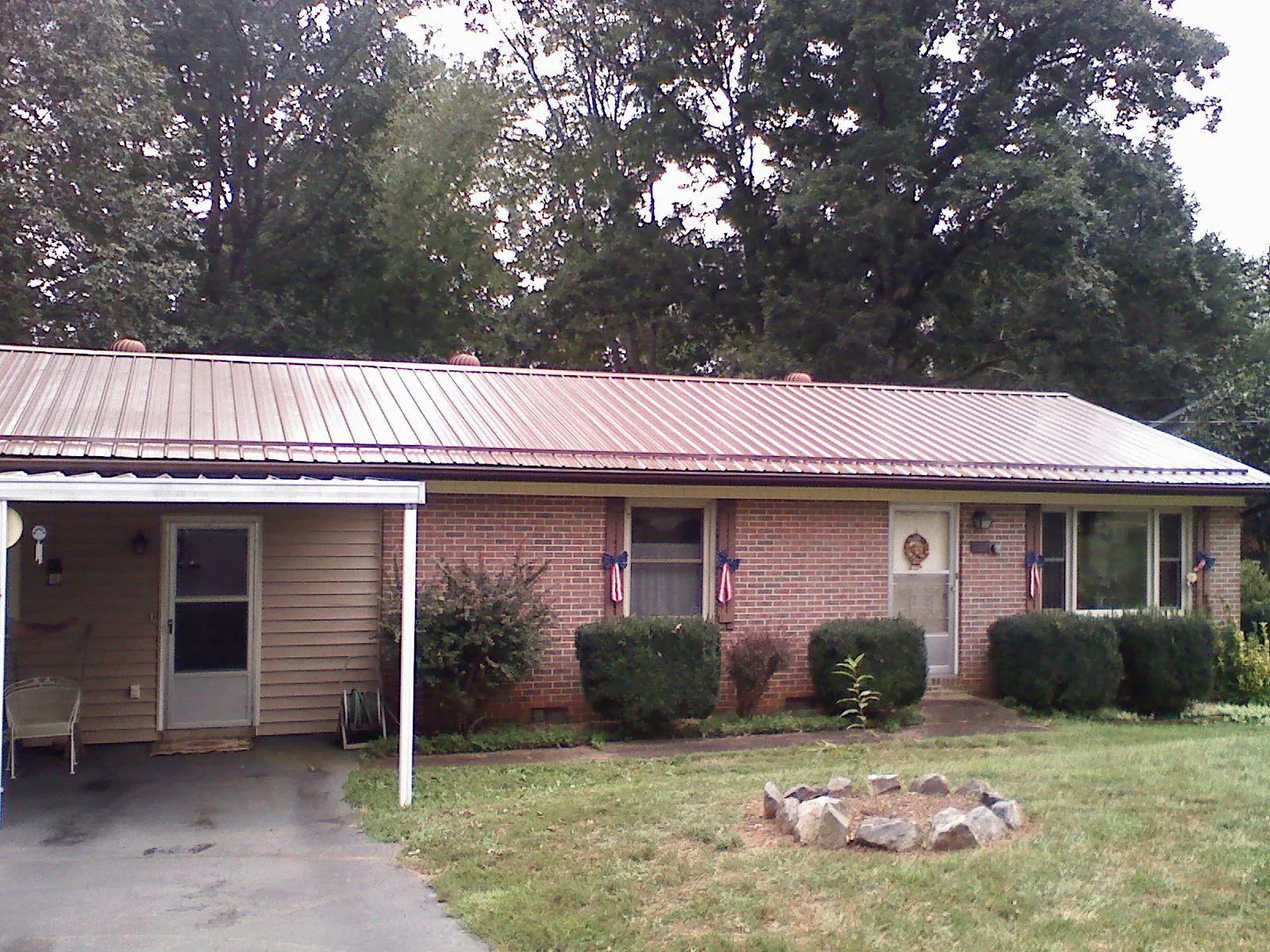 Bronze metal roof and carport on a brick ranch home — Roof Repair work by our crew in Glenmont